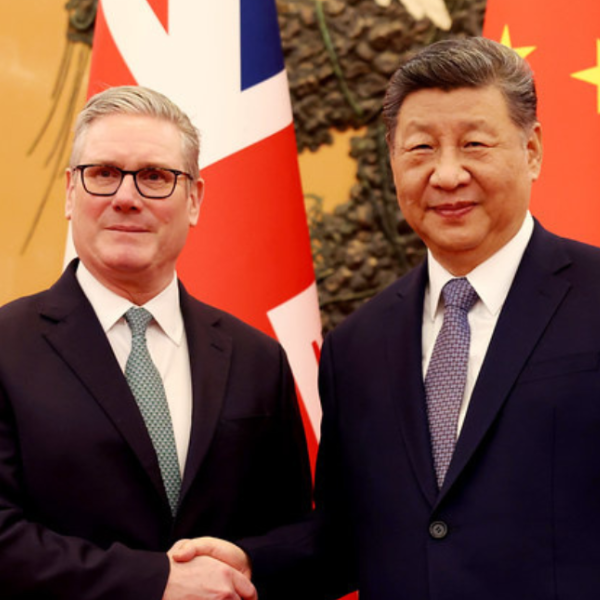Keir Starmer wears a dark suit and shakes hands with Xi Jinping, also wearing a dark suit