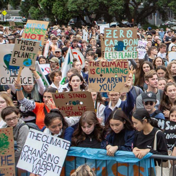 A crowd of young people hold signs at a climate protest